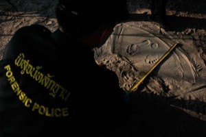 Police measure footprints of a man as data is collected from people who work near the spot where bodies of two killed British tourists were found, on the island of Koh Tao September 19, 2014. The bodies of David Miller and Hannah Witheridge were found early on Monday on the beach on Koh Tao, a southern island known for its coral reefs and diving. REUTERS/Chaiwat Subprasom (THAILAND - Tags: CRIME LAW POLITICS TRAVEL TPX IMAGES OF THE DAY) - RTR46WUC